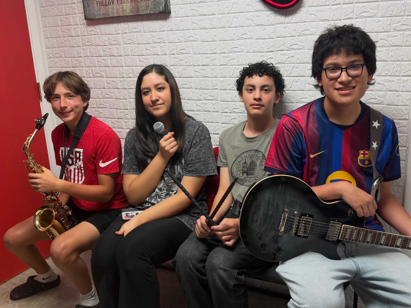 School of Talent students seated together with their instruments